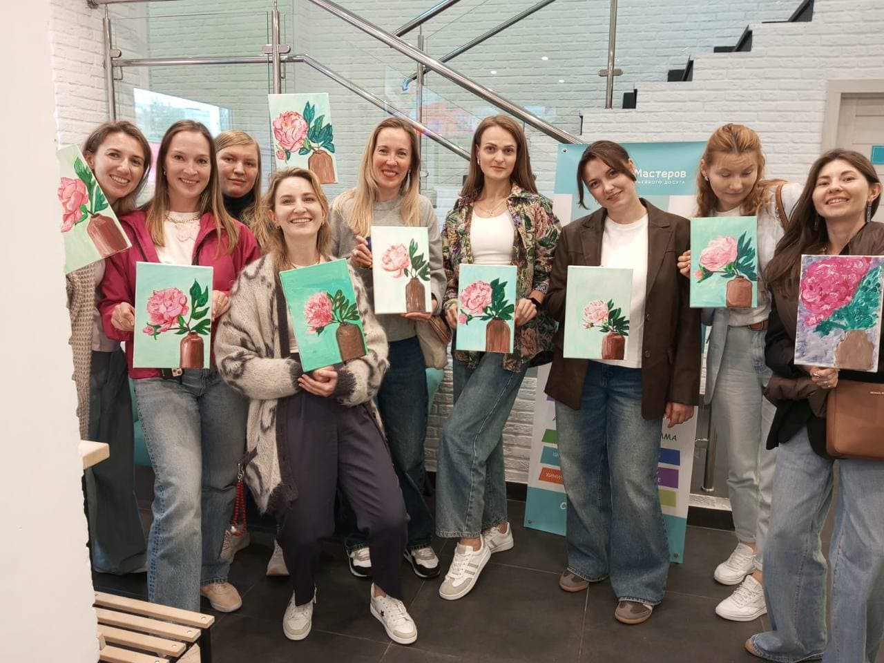 Компания девушек с одинаковыми картинами после мастер-класса