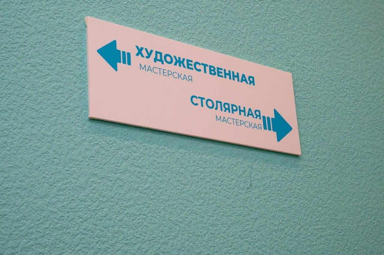 Указатель в коридоре: художественная мастерская налево, столярная направо