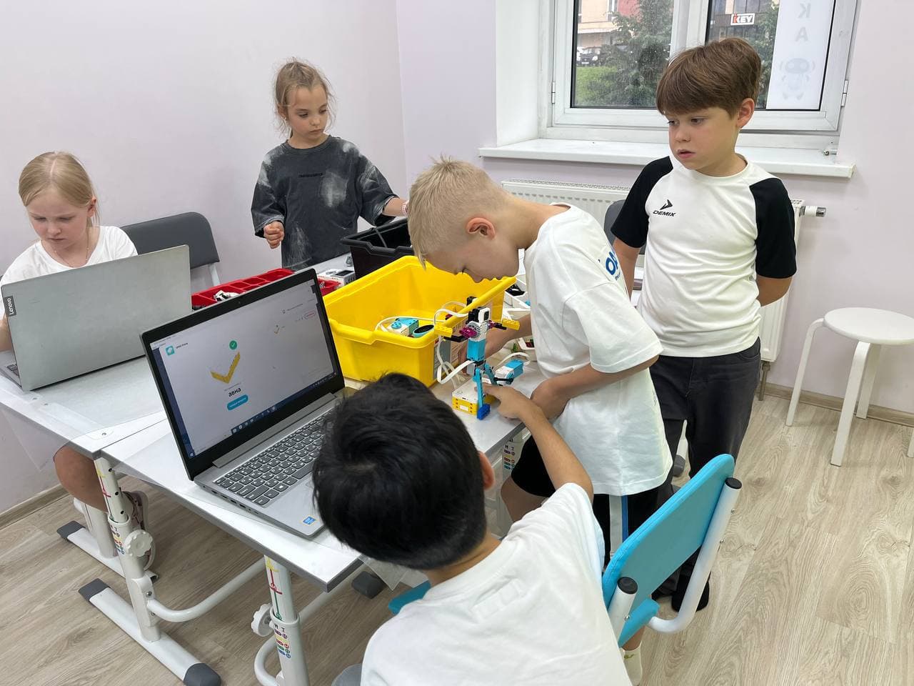 Дети собирают модели за ноутбуками в кабинете робототехники